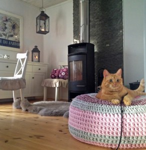 Här posar Findus på min virkade sittpuff på Landet. I bakgrunden syns även min virkade fjärilskudde av afrikanska blommor.